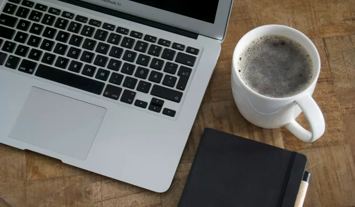 Laptop und Notizbuch auf einem Holztisch